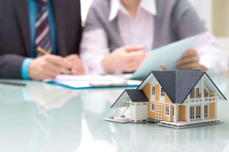 Model house on a desk during an insurance review